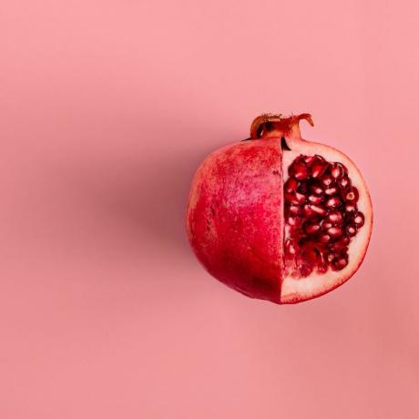 červené ovocie z granátového jablka na pastelovo ružovom pozadí