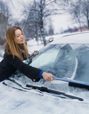žena zoškrabuje ľad z auta
